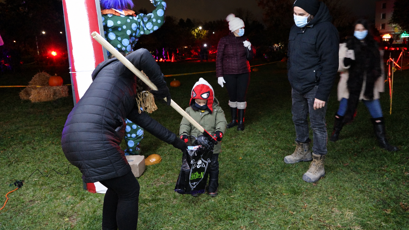 A child trick-or-treating with family at the Village After Dark Halloween celebration in 2020